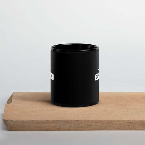 black glossy ceramic mug displayed on a wooden tray against a neutral background.
